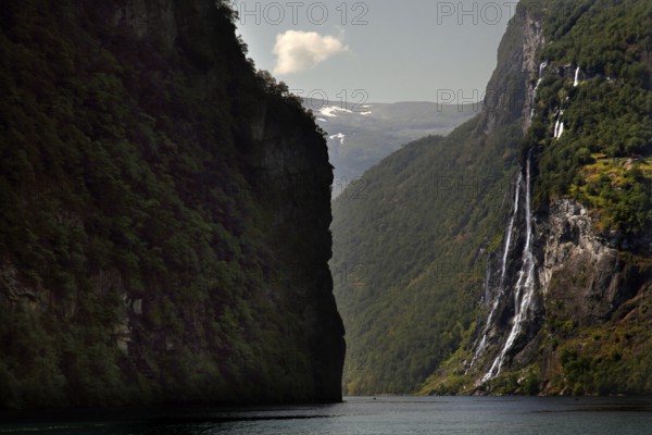Dramatic waterfall falling in Geirangerfjord surrounded by steep cliffs, Geirangerfjord, Møre og
