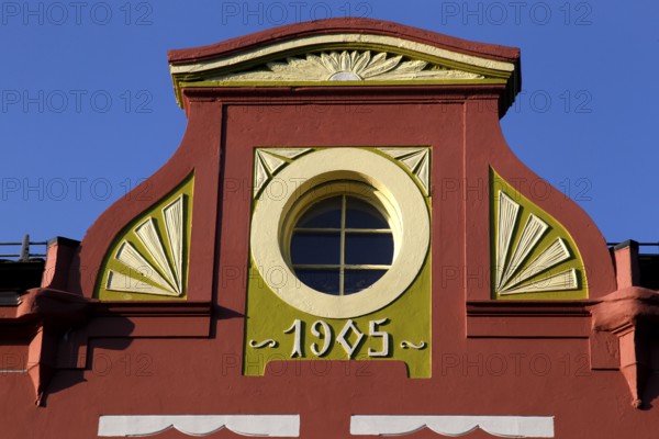 Detail of an Art Nouveau façade in Ålesund with round window opening and decorative ornaments,