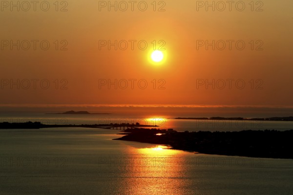 Peaceful sunset scene at Kniven viewpoint in Ålesund with orange sky, Ålesund, Norway