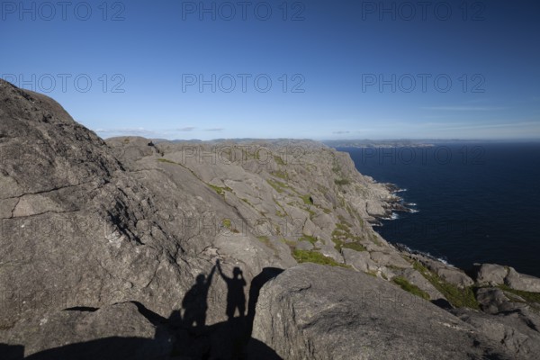 Shadow of two people giving a high five on a hiking trail view. Summer, Sandvika (Sandviga), Agder,