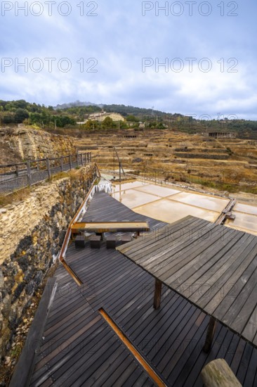 Terraced salt pans of the historic anana salt valley in alava, basque country, reflecting a cloudy