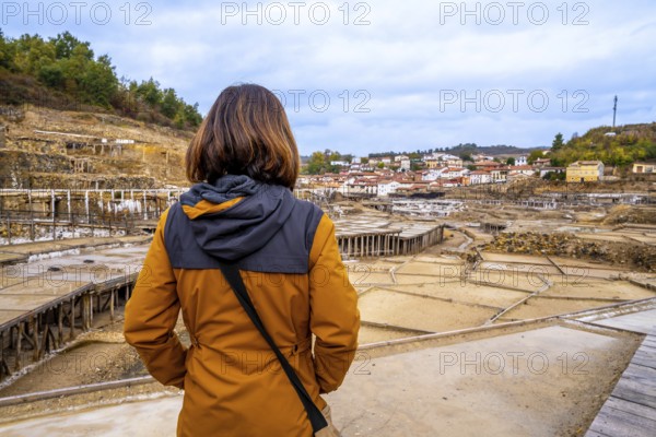 Woman tourist standing at anana salt valley, observing terraced evaporation ponds and traditional
