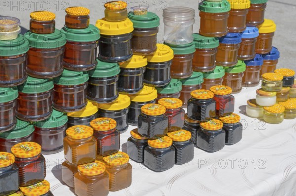 Lots of colorful honey jars with various lids on a market stand, near Gudauri, Mtskheta-Mtianeti