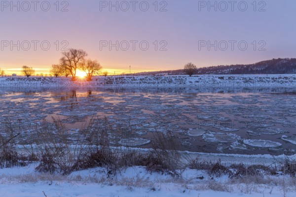 Cold winter morning on the Elbe with floating ice floes, snow and dawn at sunrise, Kötzschenbroda,