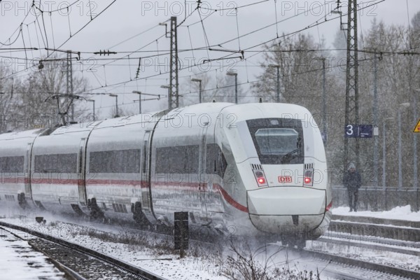 ICE traveling through a winter landscape in snowfall. A train on the line in the Deutsche Bahn