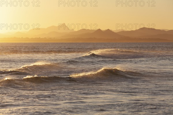 Evening light at Cape Byron with view to Mount Warning and sunlit hinterland, New South Wales,