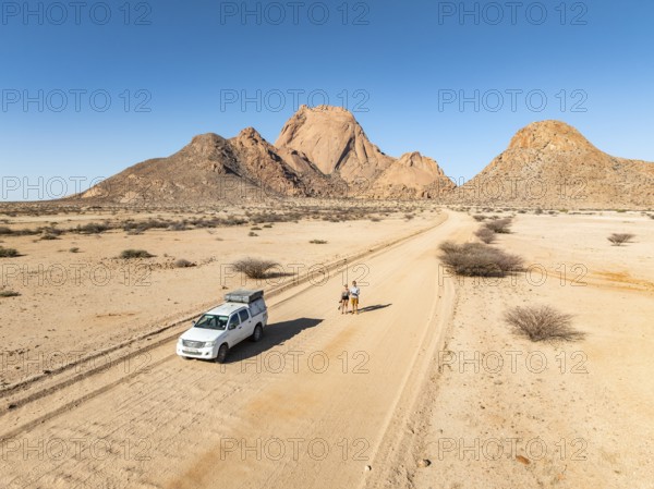 Car on sandy road, mountains in the desert, Spitzkoppe summit, Namib desert, Namibia