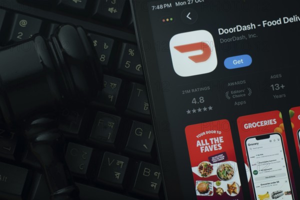 Dhaka, Bangladesh- 28 Oct 2025: An iPad displaying the DoorDash app against a judge's gavel and