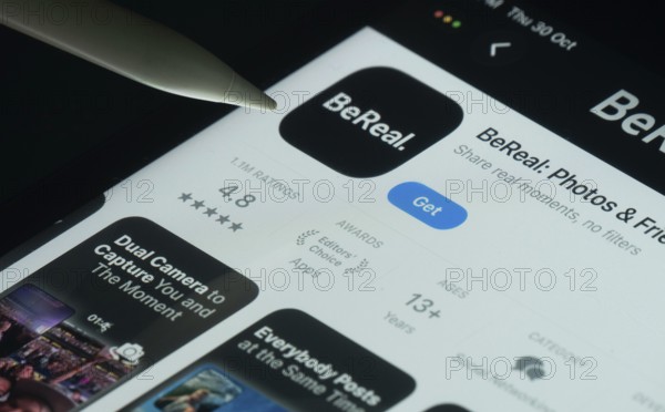 Dhaka, Bangladesh- 30 Oct 2025: BeReal app on a iPad screen with a pen pointing at the install