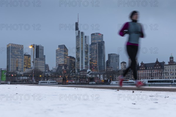 The towers of the Frankfurt banking skyline rise behind the snow-covered banks of the Main,