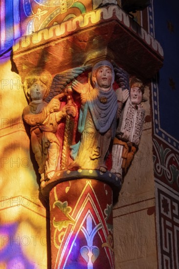 Issoire. Pillar (The Annunciation made to Mary) . The figures are illuminated by colorful light