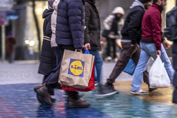 Pedestrian zone, passers-by hurrying, shopping between the years, exchanging, shopping bags,