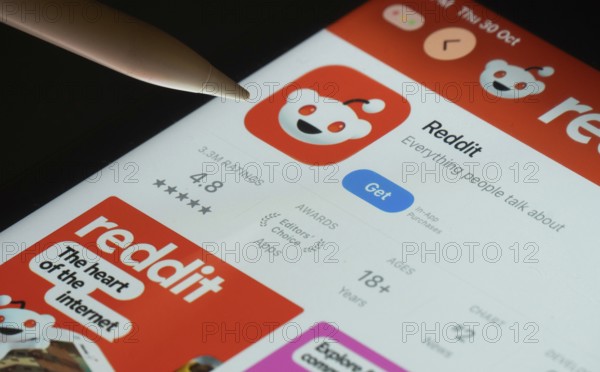 Dhaka, Bangladesh- 30 Oct 2025: Reddit app on a iPad screen with a pen pointing at the install