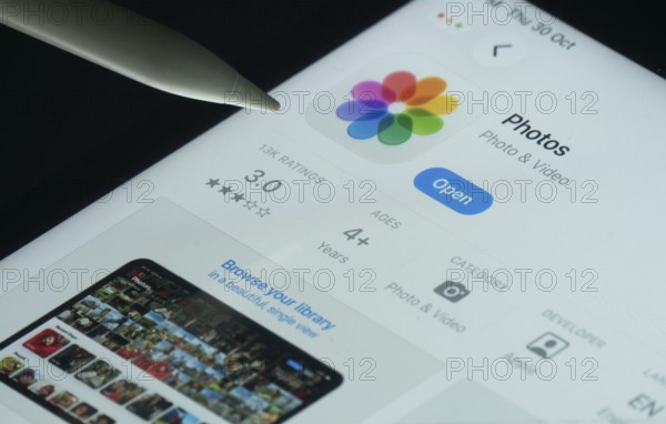 Dhaka, Bangladesh- 30 Oct 2025: Apple Photos app on a iPad screen with a pen pointing at the