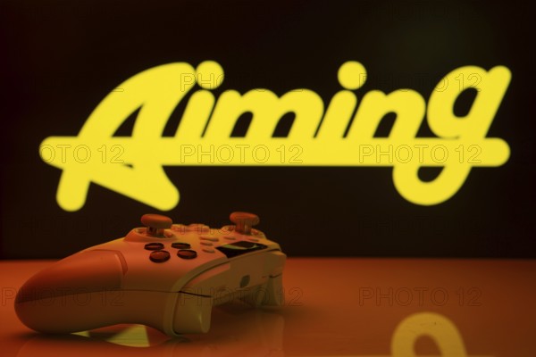 Dhaka, Bangladesh- 20 Mar 2025: A close-up of a white gamepad with the Aiming Inc seen on screen in