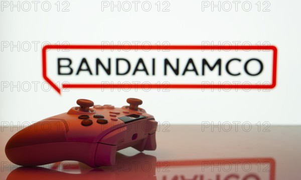 Dhaka, Bangladesh- 20 Mar 2025: A close-up of a white gamepad with the Bandai Namco seen on screen