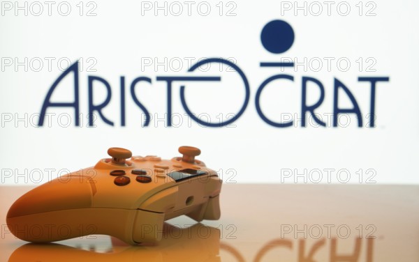 Dhaka, Bangladesh- 20 Mar 2025: A close-up of a white gamepad with the Aristocrat seen on screen in