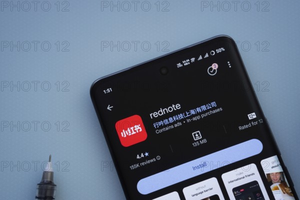 Dhaka, Bangladesh- 29 May 2025: On a blue surface, a smartphone displays the rednote app within the