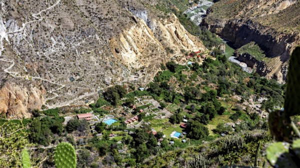 Small village surrounded by a green oasis in a rocky gorge landscape, the landscape of the Colca