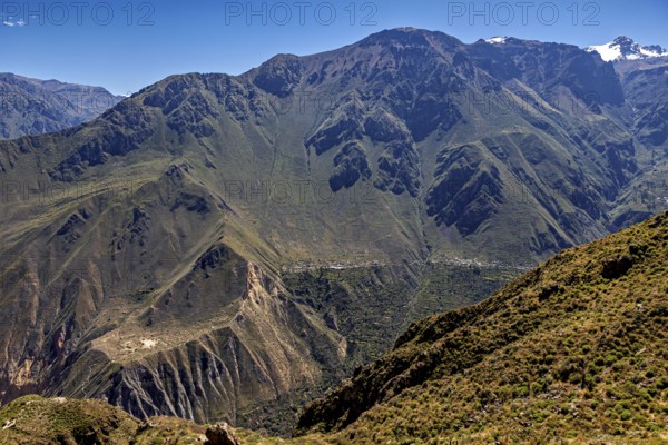 Extensive mountain landscape with a deep gorge, overgrown and under clear skies, The landscape of