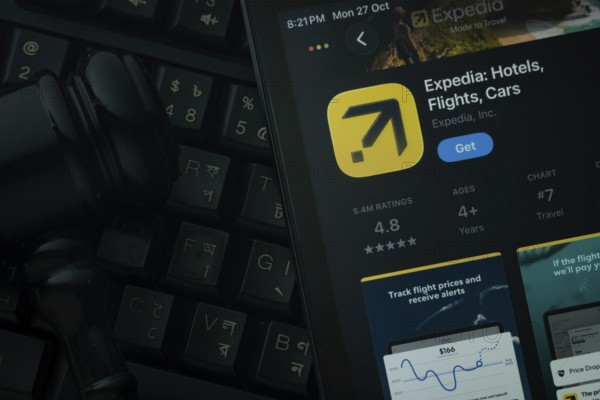 Dhaka, Bangladesh- 28 Oct 2025: An iPad displaying the Expedia app against a judge's gavel and dark