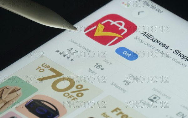 Dhaka, Bangladesh- 21 Nov 2025: AliExpress app on a iPad screen with a pen pointing at the install