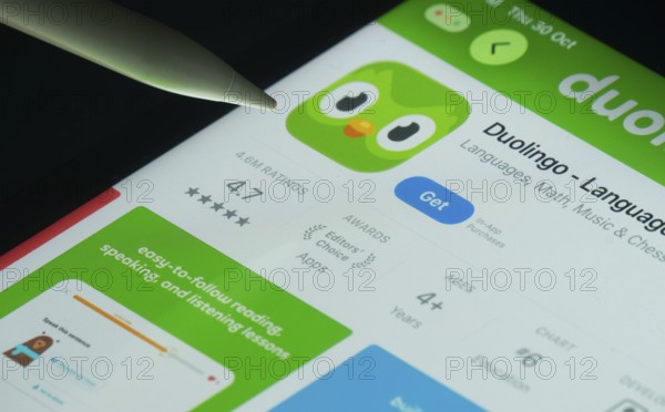 Dhaka, Bangladesh- 30 Oct 2025: Duolingo app on a iPad screen with a pen pointing at the install