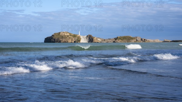 Castlepoint Beach and Castlepoint Lighthouse, ocean, waves, surf, sandy beach, rocks. Castlepoint,