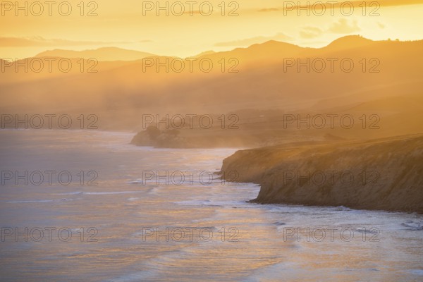 Wairarapa coast at sunset. Sea, mountains, backlight. Castlepoint, Wairarapa Coast, Wellington