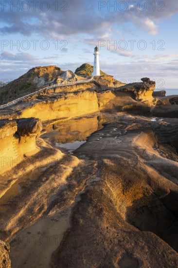 Castlepoint lighthouse on a rock, sea, sunrise. Castlepoint, Wairarapa Coast, Wellington Region,