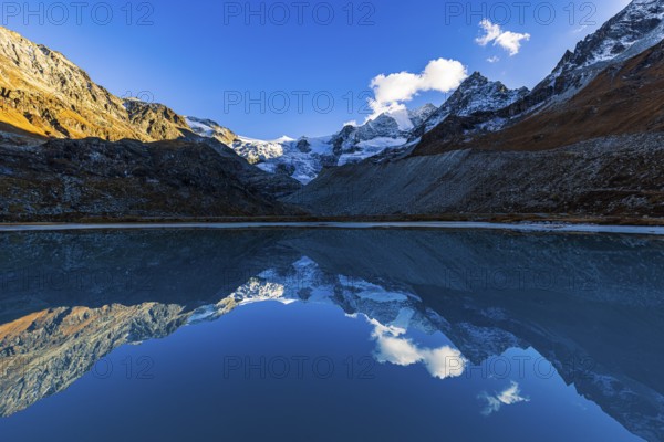 The Moiry glacier and mountain peaks are reflected in Lac de Chateaupre, Val d'Anniviers, Valais