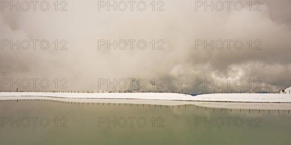 Another onset of winter in May, Riezler Alpsee, an artificially created lake, snow pond, feeds the
