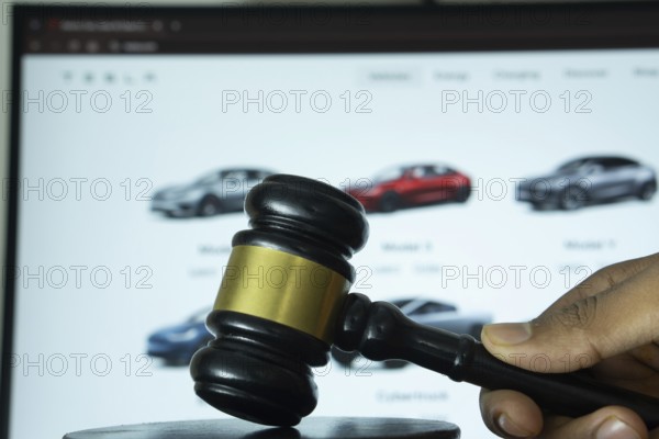 Dhaka, Bangladesh- 20 June 2025: A hand holds a gavel in front of a computer screen displaying