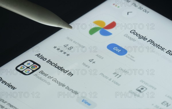 Dhaka, Bangladesh- 30 Oct 2025: Google Photos app on a iPad screen with a pen pointing at the