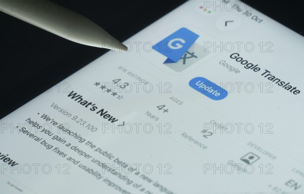Dhaka, Bangladesh- 30 Oct 2025: Google Translate app on a iPad screen with a pen pointing at the