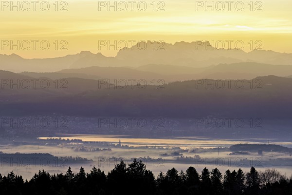 View from Horben of Lake Zug with the city of Cham and Zug covered in fog, behind it the