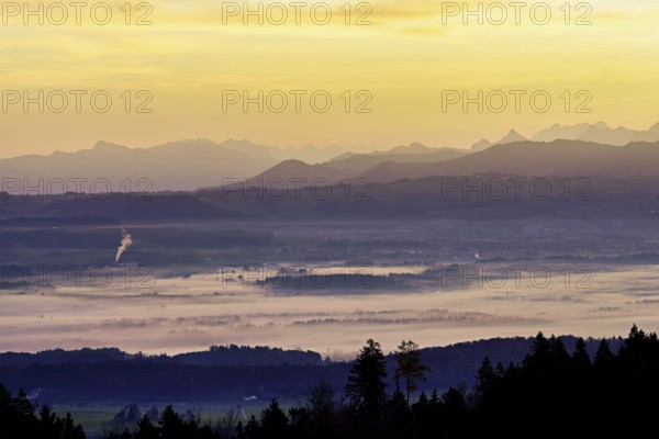 View from Horben of the Reuss Valley covered in fog, behind it the Glarus Alps in the light of the