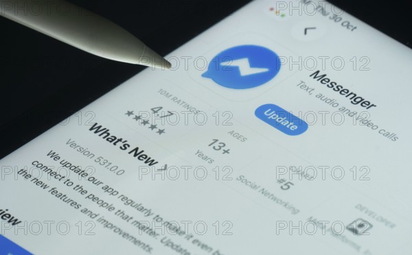 Dhaka, Bangladesh- 30 Oct 2025: Facebook Messenger app on a iPad screen with a pen pointing at the