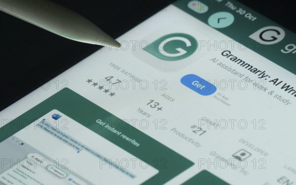 Dhaka, Bangladesh- 30 Oct 2025: Grammarly app on a iPad screen with a pen pointing at the install