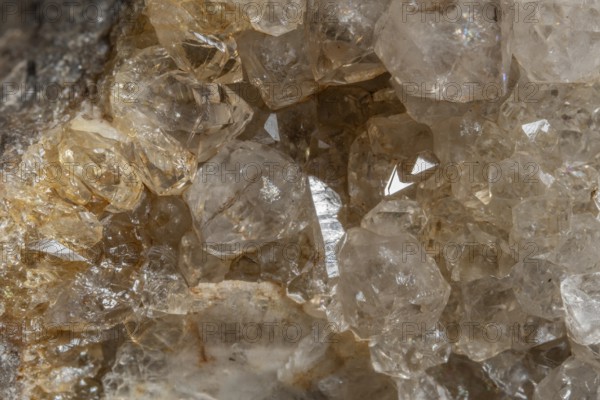 Bright, square crystals are visible on a piece of rock. The light underlines their structure and
