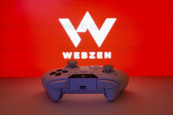 Dhaka, Bangladesh- 14 Nov 2025: A close-up of a white gamepad with the Webzen seen on screen in the