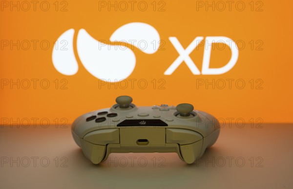Dhaka, Bangladesh- 14 Nov 2025: A close-up of a white gamepad with the XD seen on screen in the