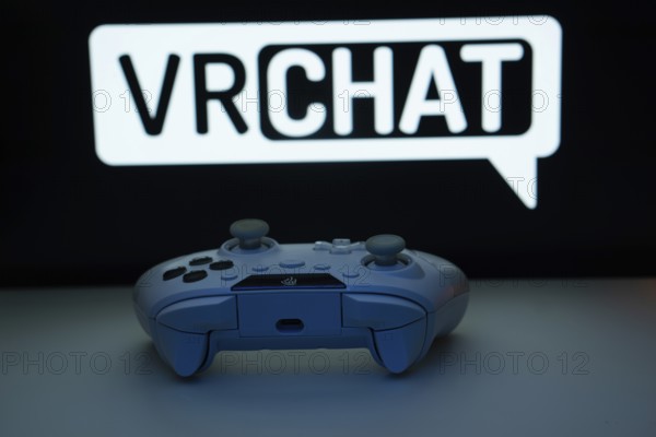 Dhaka, Bangladesh- 14 Nov 2025: A close-up of a white gamepad with the VRChat seen on screen in the