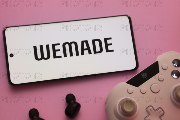 Dhaka, Bangladesh- 22 Mar 2025: Smartphone with WeMade Entertainment logo, game controller, and