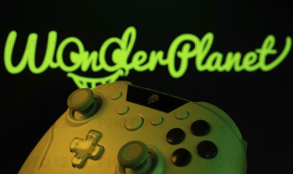 Dhaka, Bangladesh- 14 Nov 2025: A close-up of a gamepad with the WonderPlanet Inc seen on screen in