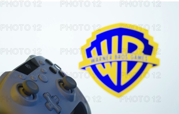 Dhaka, Bangladesh- 14 Nov 2025: A close-up of a gamepad with the Warner Bros. Games seen on screen