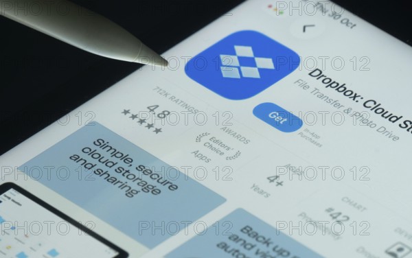 Dhaka, Bangladesh- 30 Oct 2025: Dropbox app on a iPad screen with a pen pointing at the install