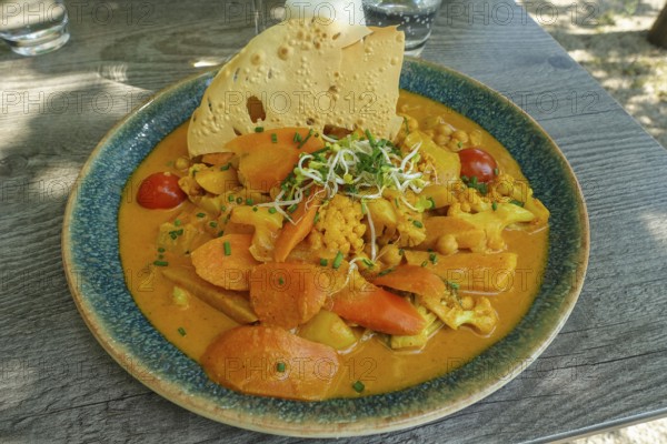 Asian cuisine, mixed vegetables, carrots, cauliflower, bamboo, cherry tomatoes, curry sauce,