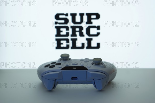 Dhaka, Bangladesh- 14 Nov 2025: A close-up of a white gamepad with the Supercell seen on screen in