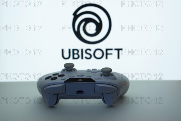 Dhaka, Bangladesh- 14 Nov 2025: A close-up of a white gamepad with the Ubisoft seen on screen in